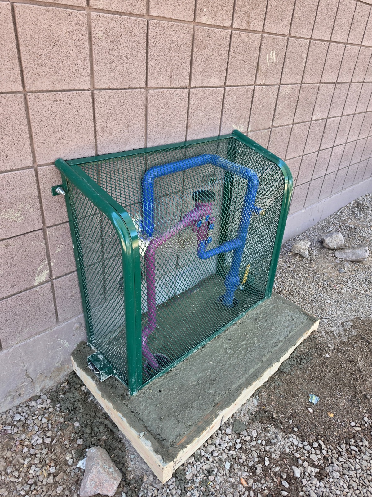 Commercial backflow preventer installed inside a protective security cage in Phoenix