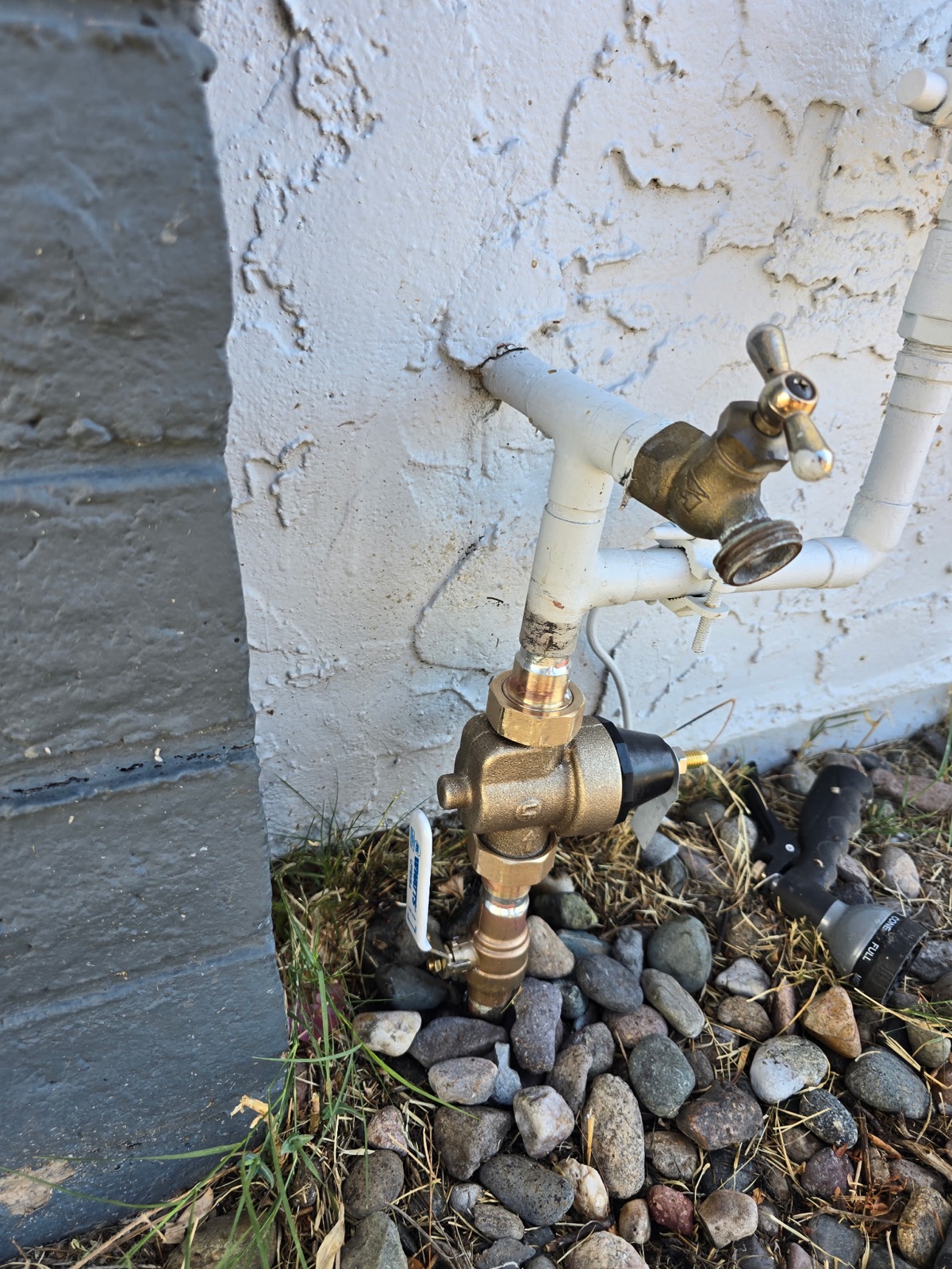 Pressure reducing valve and hose bib installed on a stucco wall in Phoenix