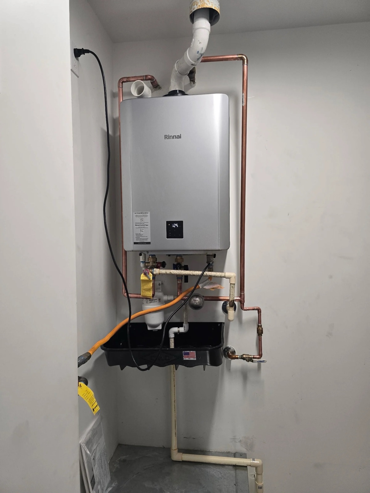 Rinnai condensing tankless water heater with PVC venting installed in a Phoenix utility closet