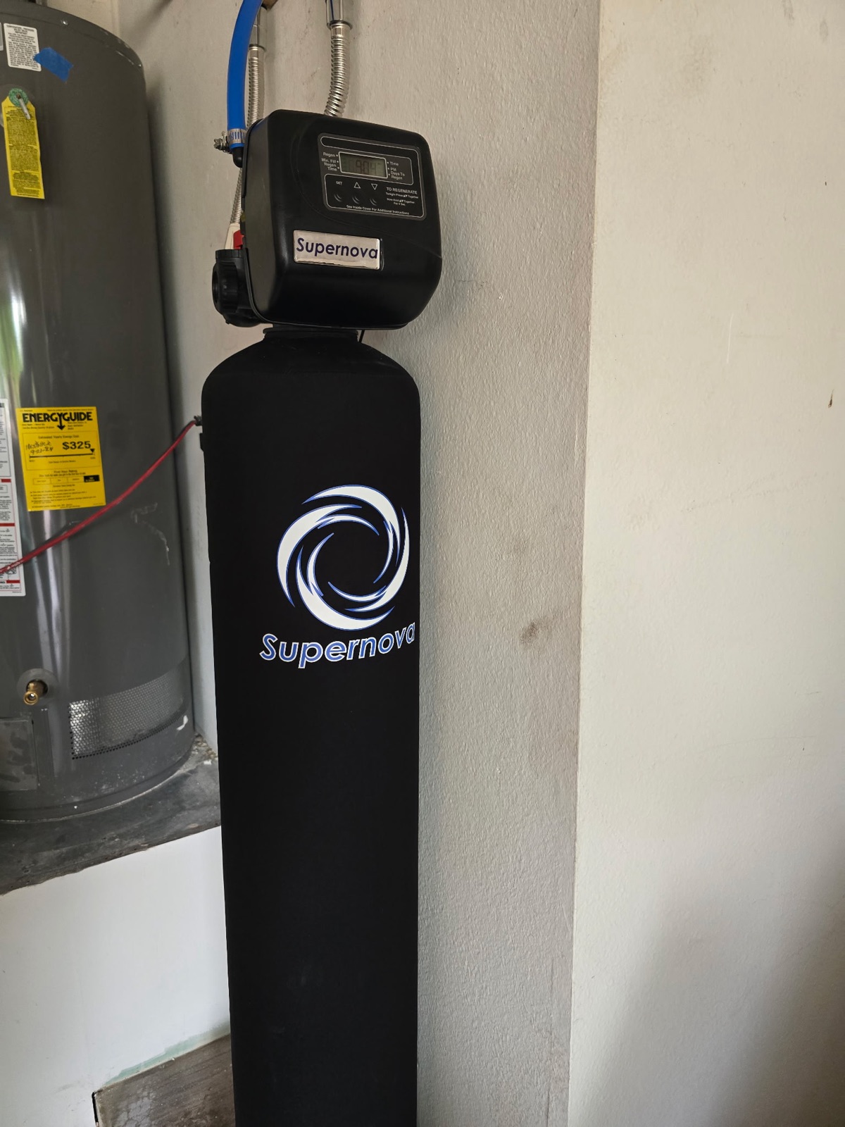 Supernova water softener installed beside a tank water heater in a Phoenix garage